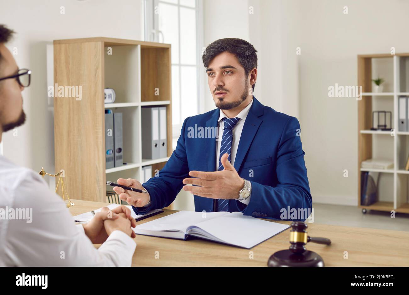 Incontro in carica di studio legale di avvocato maschile e il suo cliente commerciale per consulenza legale. Foto Stock