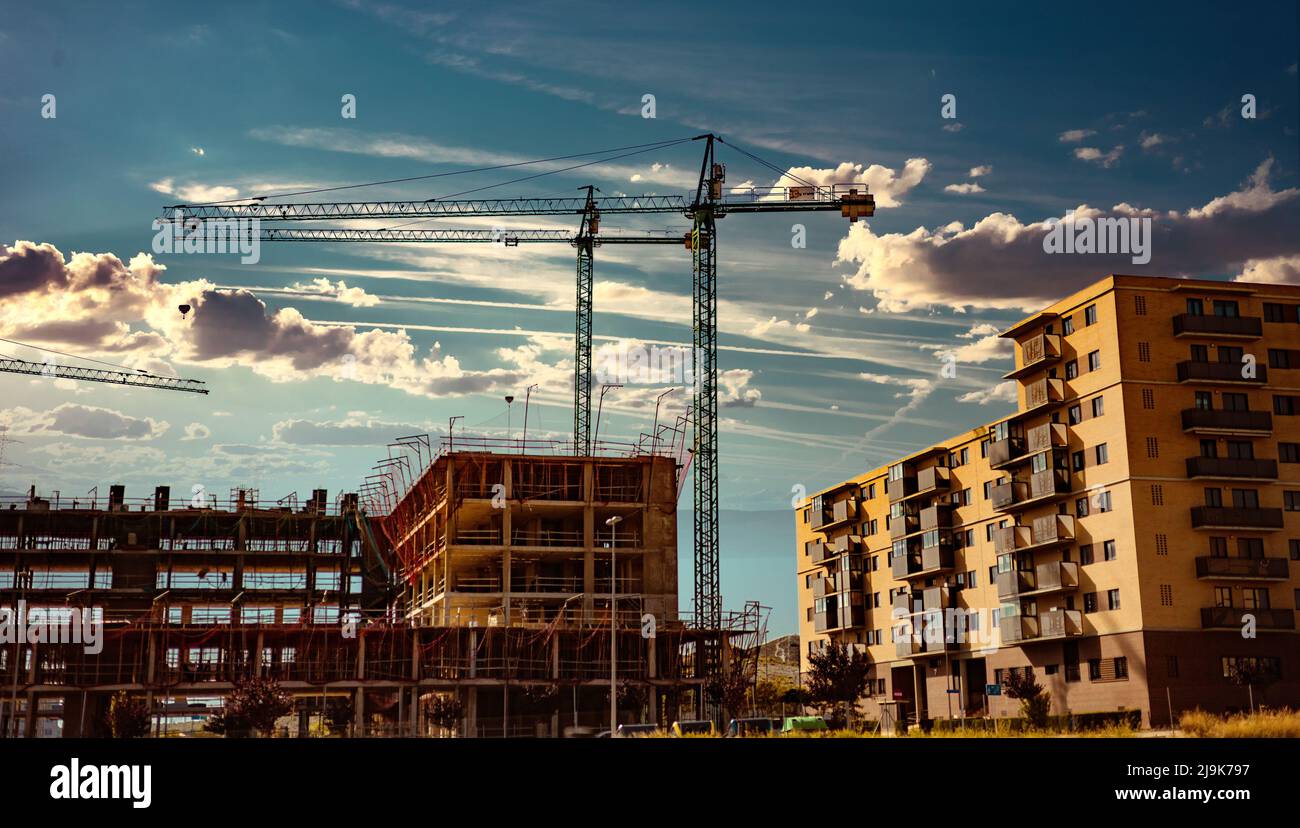 Paesaggio tramonto e costruzione gru ed edifici. Costruire con gru da costruzione. Foto Stock