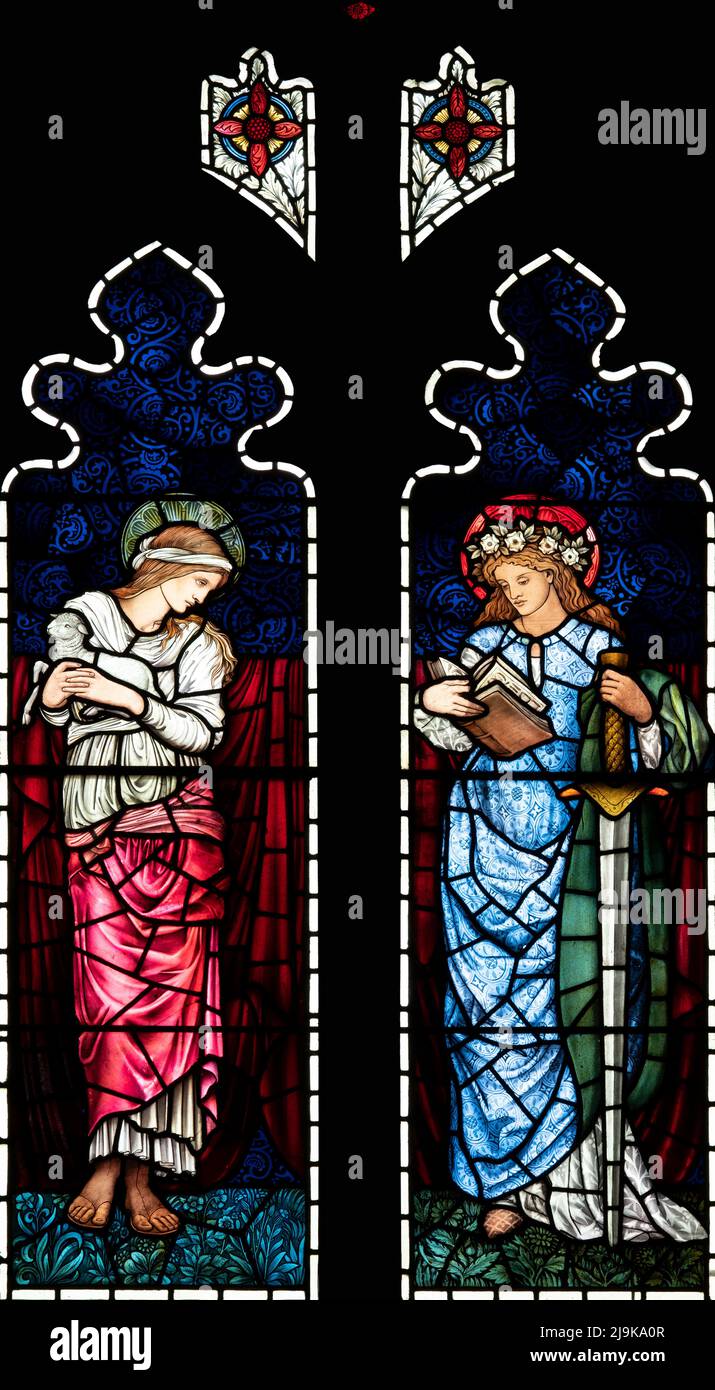 Due 'Virgin Martyrs', St Agnes e St Catherine, raffigurati da Edward Burne-Jones e William Morris, St Paul's Church, Irton, Cumbria, UK Foto Stock