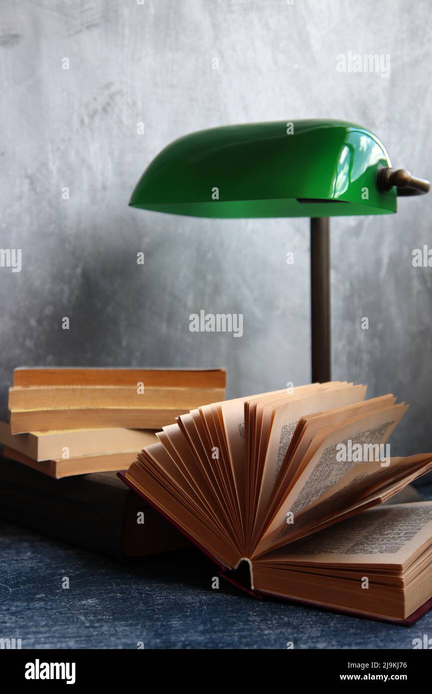 Semplice composizione ancora vita con lampada vintage e libro su una scrivania. Foto ravvicinata con oggetti in stile retrò. Foto Stock