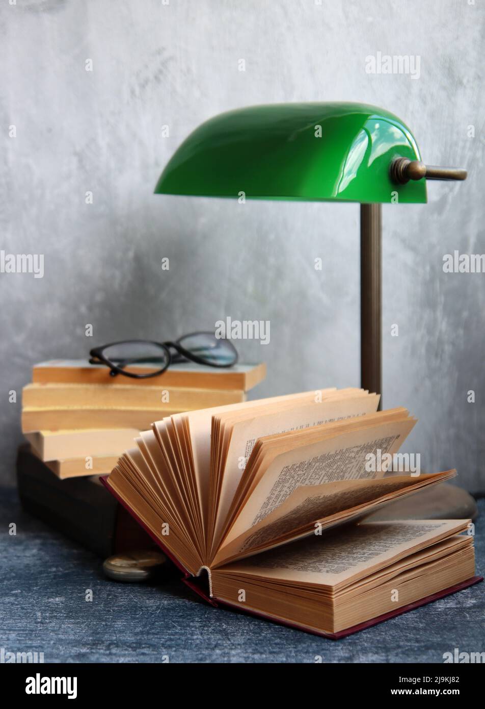 Semplice composizione ancora vita con lampada vintage e libro su una scrivania. Foto ravvicinata con oggetti in stile retrò. Foto Stock