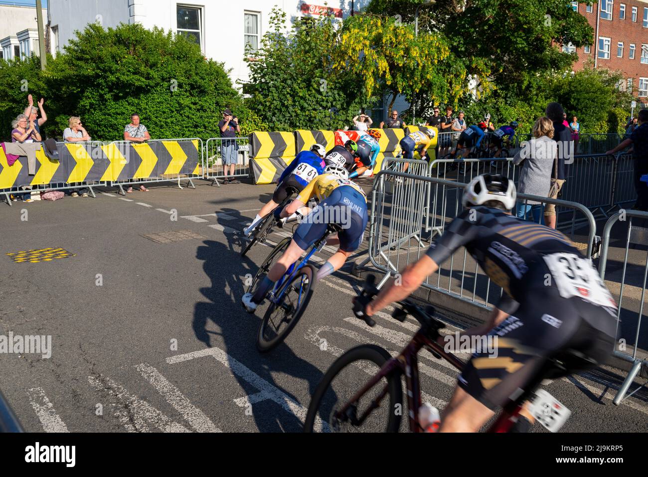 Ciclisti che corrono nella gara ciclabile Sportsbreaks Tour Series, round five a Clacton on Sea, Essex, Regno Unito. Gara di strada criterium che prende una curva netta Foto Stock