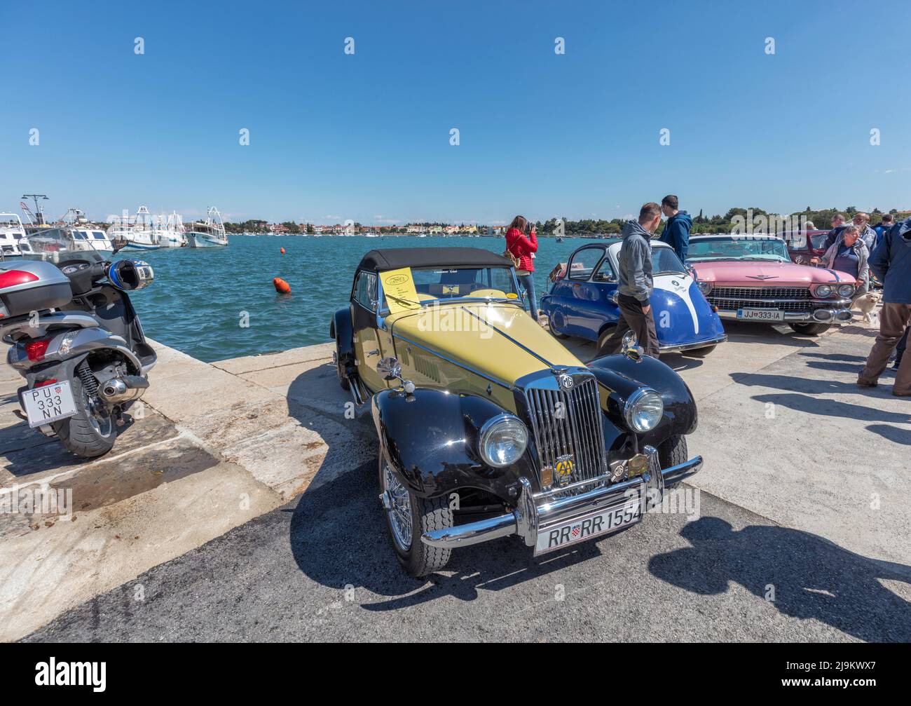 Auto sportive MG e altre auto d'epoca si riuniscono per incontrarsi a Riva Umago, lungomare vicino al porto. Umago, Croazia Foto Stock