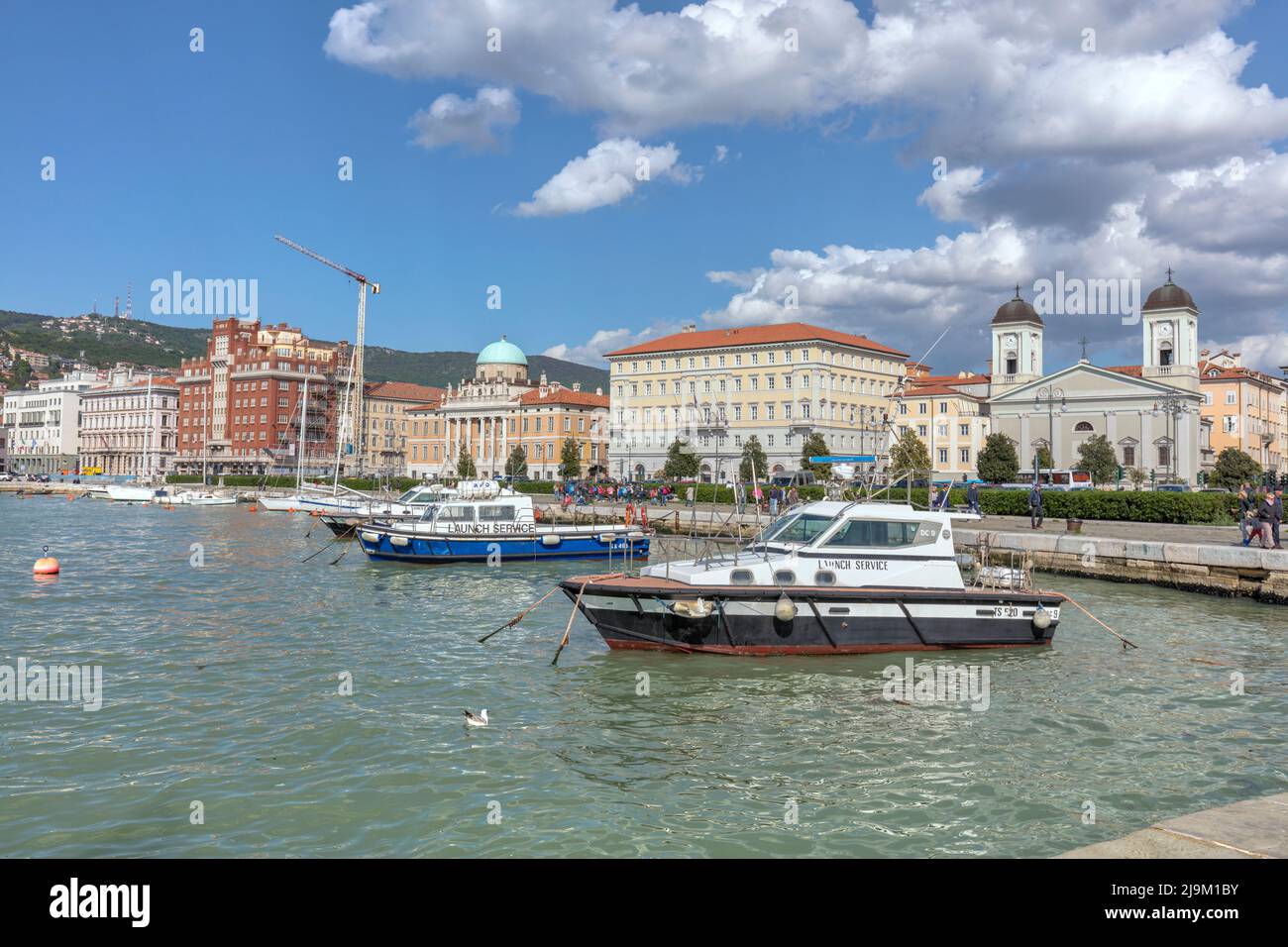 Barche ormeggiate sul lungomare (Riva tre Novembre) viste dal Molo Audace - un molo in pietra del 200m nel mare Adriatico acquamarina, Golfo di Trieste, Trieste, Italia Foto Stock