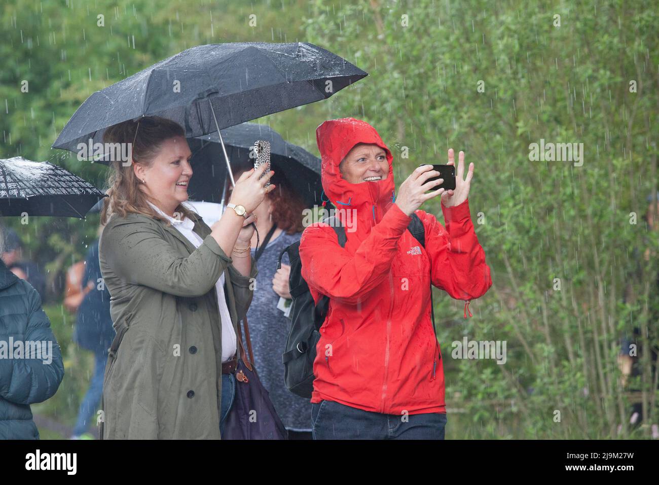 Londra, UK, 24 maggio 2022: Il RHS Chelsea Flower Show è stato aperto al pubblico oggi, con gli amanti delle piante che godono di esposizioni specializzate nel tendone e nei giardini dello spettacolo. Dopo una mattinata di sole una breve tempesta di tuono a pranzo ha inviato alcune persone che corrono per la copertura, ma alcuni amanti del giardino devoti hanno messo i loro brorli e hanno portato avanti. Anna Watson/Alamy Live News Foto Stock
