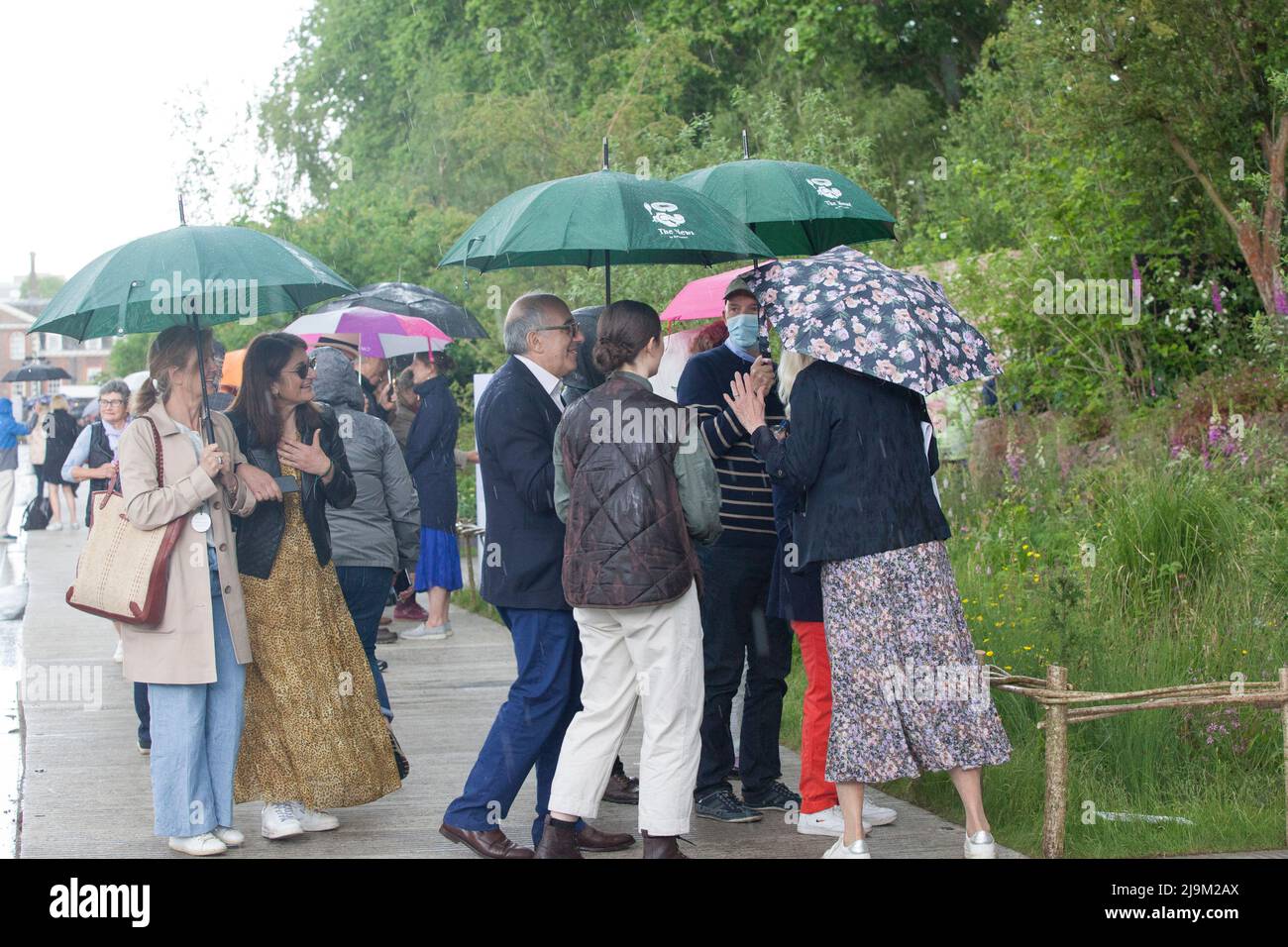 Londra, UK, 24 maggio 2022: Il RHS Chelsea Flower Show è stato aperto al pubblico oggi, con gli amanti delle piante che godono di esposizioni specializzate nel tendone e nei giardini dello spettacolo. Dopo una mattinata di sole una breve tempesta di tuono a pranzo ha inviato alcune persone che corrono per la copertura, ma alcuni amanti del giardino devoti hanno messo i loro brorli e hanno portato avanti. Anna Watson/Alamy Live News Foto Stock