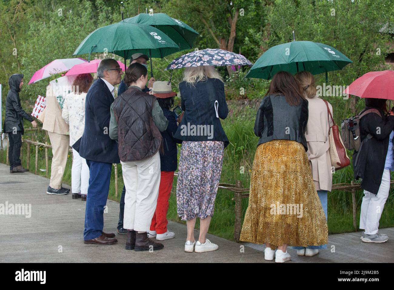 Londra, UK, 24 maggio 2022: Il RHS Chelsea Flower Show è stato aperto al pubblico oggi, con gli amanti delle piante che godono di esposizioni specializzate nel tendone e nei giardini dello spettacolo. Dopo una mattinata di sole una breve tempesta di tuono a pranzo ha inviato alcune persone che corrono per la copertura, ma alcuni amanti del giardino devoti hanno messo i loro brorli e hanno portato avanti. Anna Watson/Alamy Live News Foto Stock