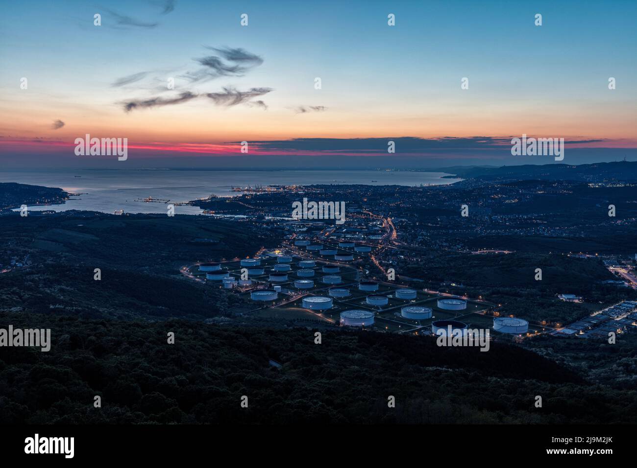 Storica città portuale di Trieste e dell'Adriatico al tramonto, al crepuscolo visto dal castello di San Servolo (Grad Socerb nell'altopiano carsico in Slovenia. Trieste. Foto Stock