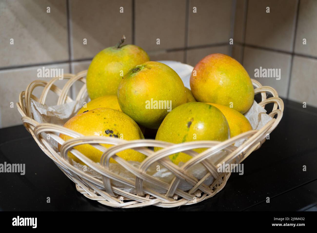 Manghi freschi maturi dai colori vivaci in un cestino di frutta. Messa a fuoco selettiva. Foto Stock
