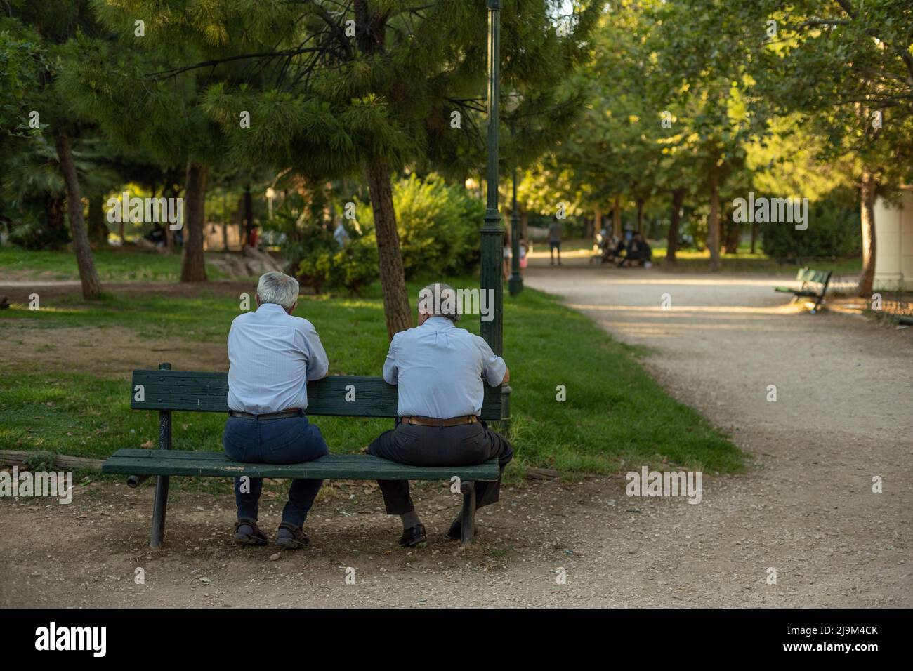 Amici in pensione si incontrano per una chat su una panchina del parco. Fix Parco pubblico di Atene. Foto Stock
