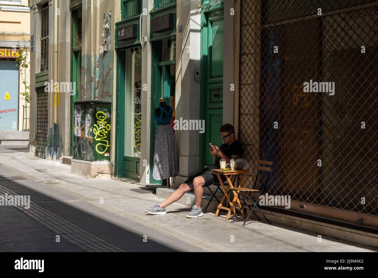 Pausa caffè in una strada tranquilla ad Atene Foto Stock