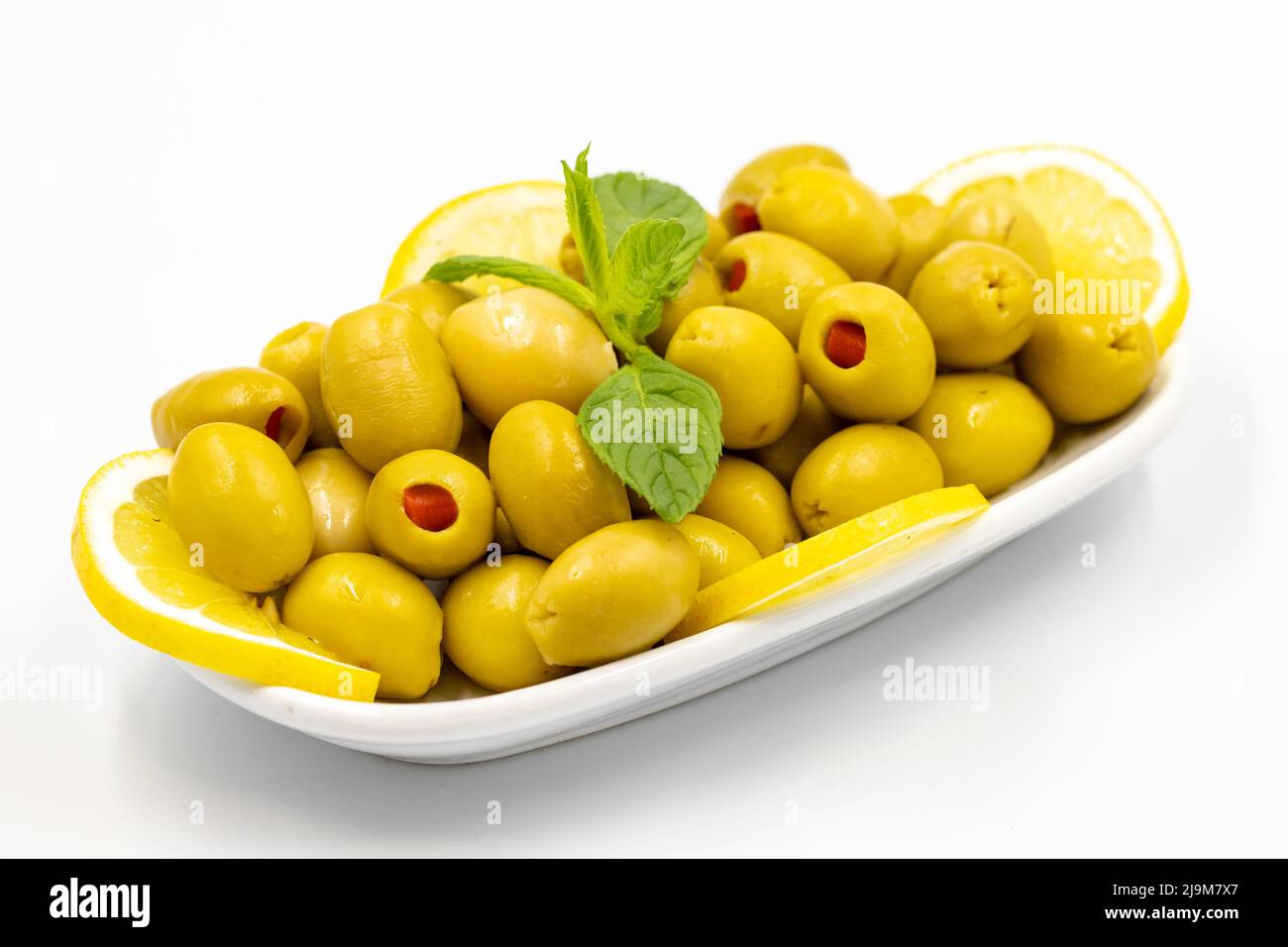 Olive verdi farcite con peperoni. Olive naturali pepperate su fondo bianco isolato. Cibo sano. Primo piano Foto Stock