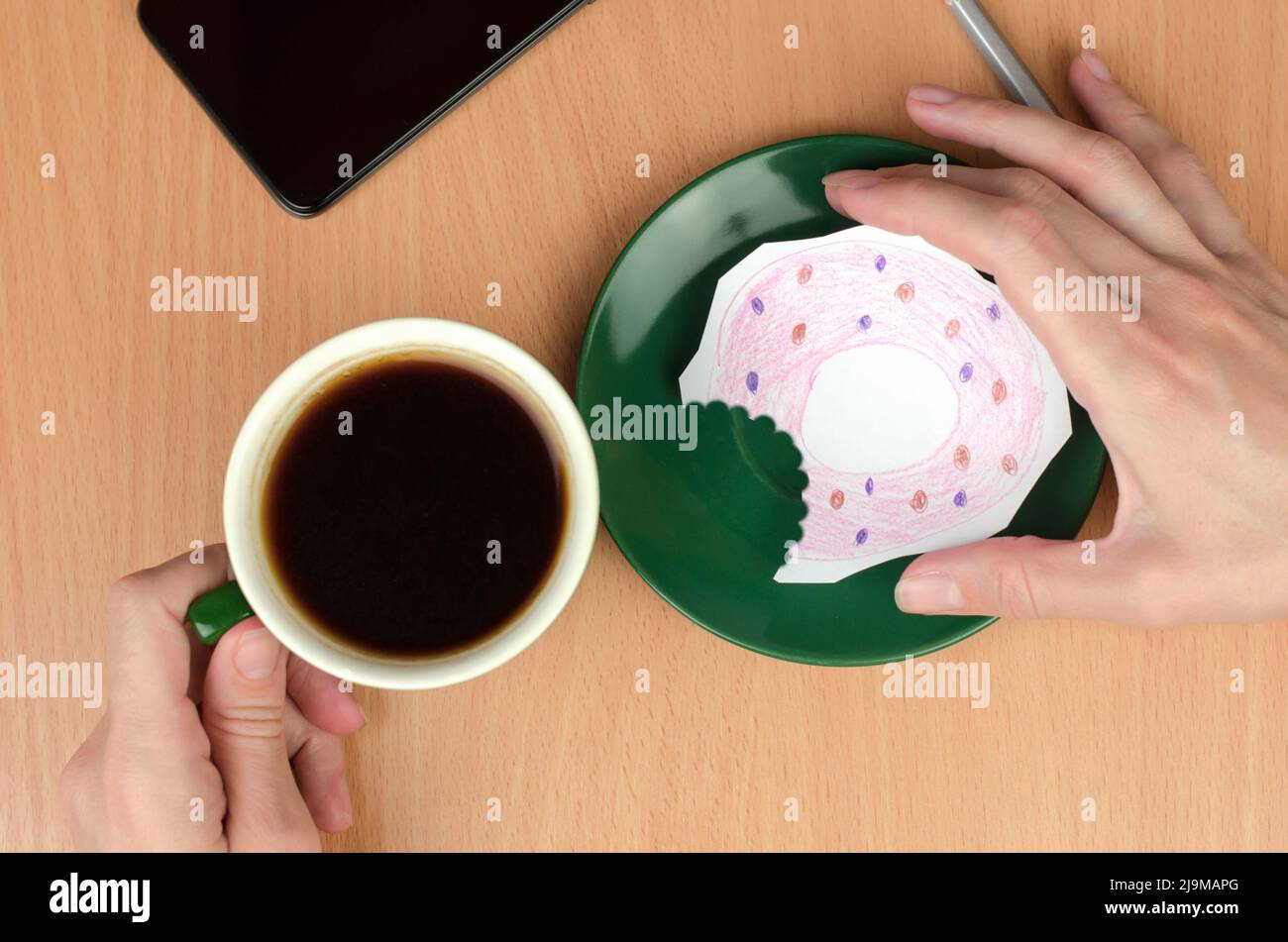 Una tazza di caffè e una ciambella dipinta su un piattino. Il concetto di mancanza di cibo o di denaro Foto Stock