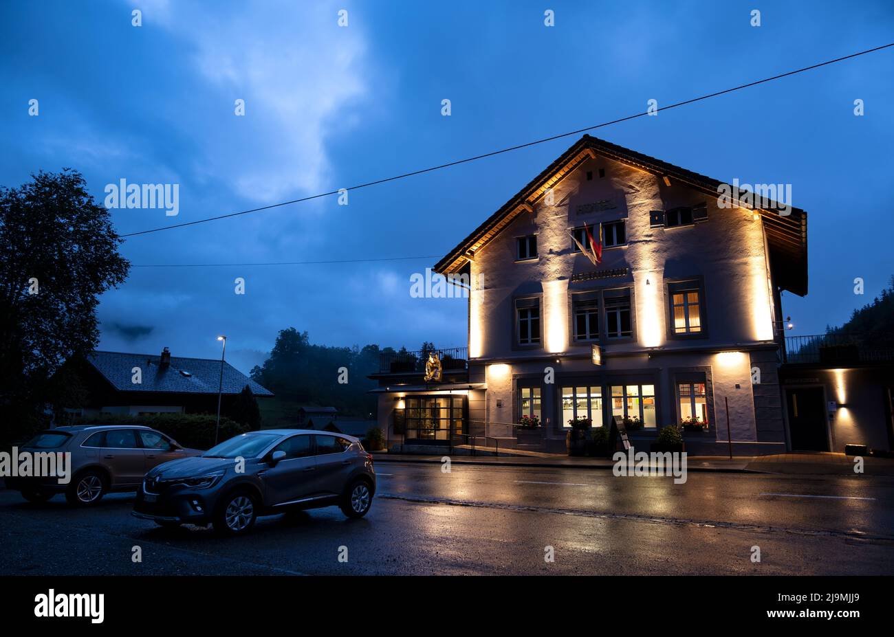 Vista dell'ora blu del ristorante in legno illuminato situato nel villaggio alpino di Hasliberg, Svizzera. Foto Stock