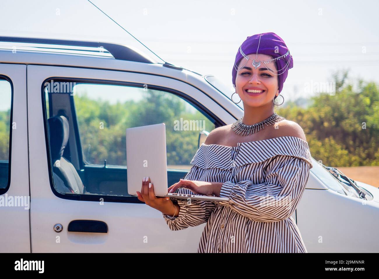 Business Afro-americana donna imprenditore datore di lavoro con trucco in abito di lavoro vicino auto con computer portatile Foto Stock