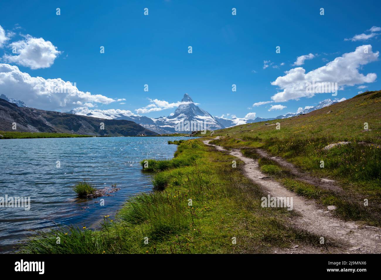 Pittoresco paesaggio del lago Stellisee, con il picco innevato del Cervino e prati verdi catturati a Zermatt, in Svizzera. Foto Stock