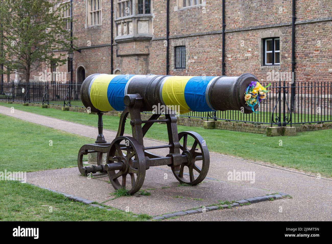 Colori giallo e blu drappeggiato sul cannone che si trova di fronte alla Cattedrale di Ely nel sud dell'Ucraina dopo essere stato invaso dalla Russia nel 2022. Preso Foto Stock