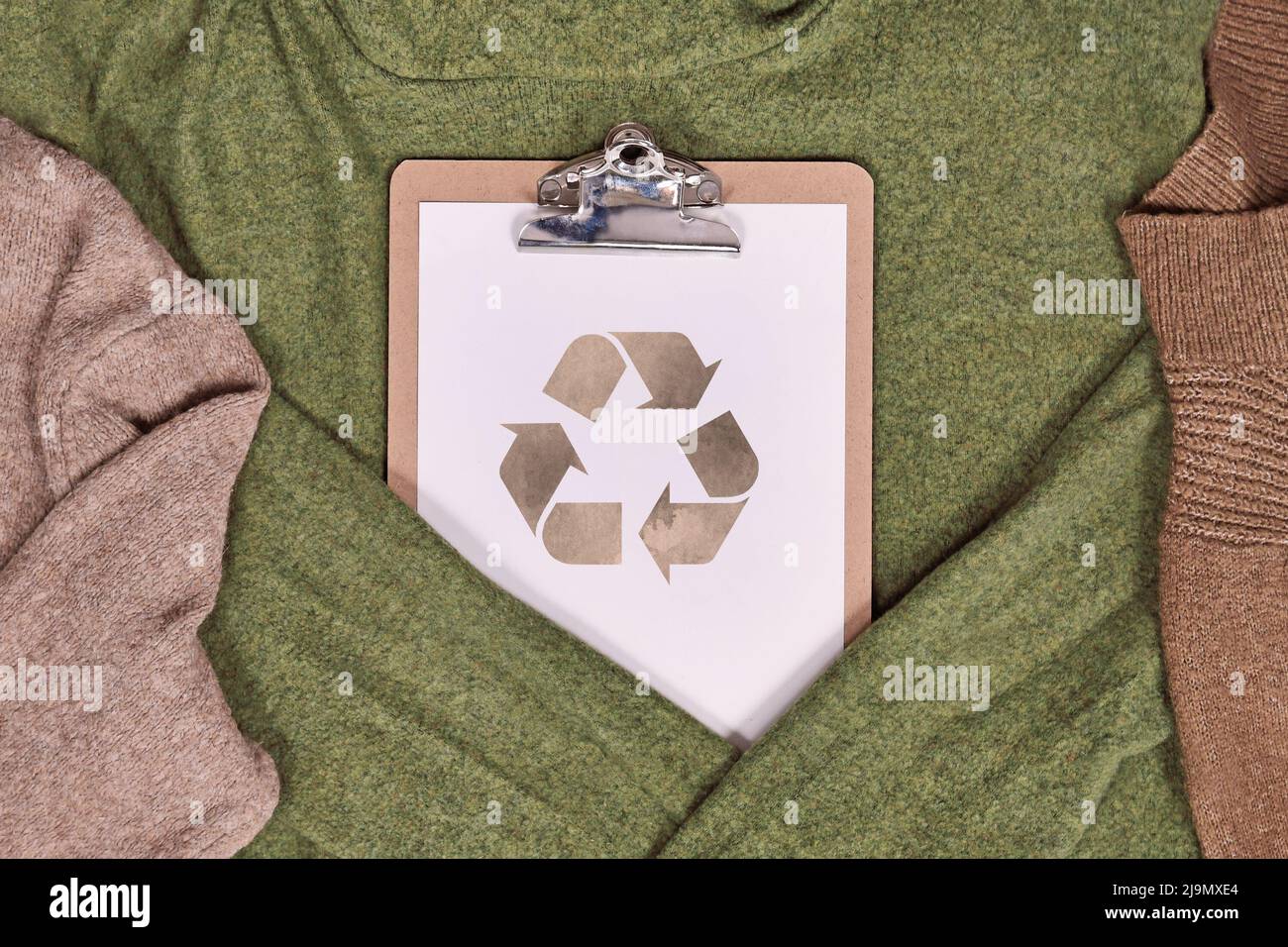 Concetto di abbigliamento ecologico prodotto con maglioni e simbolo di riciclaggio Foto Stock