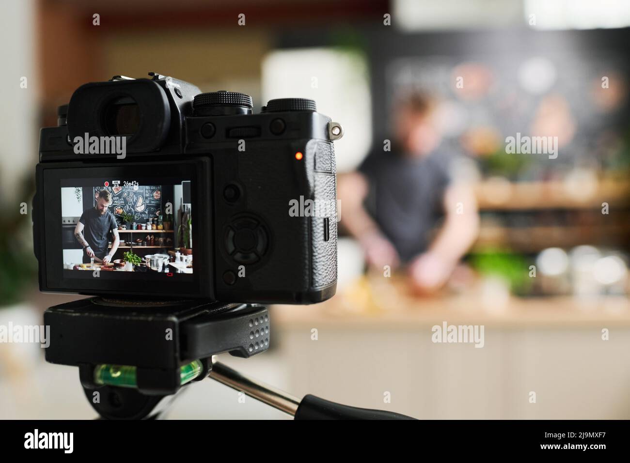 Primo piano focus selettivo sulla fotocamera scattata dallo chef maschile caucasico moderno che prepara una lezione di cucina online Foto Stock