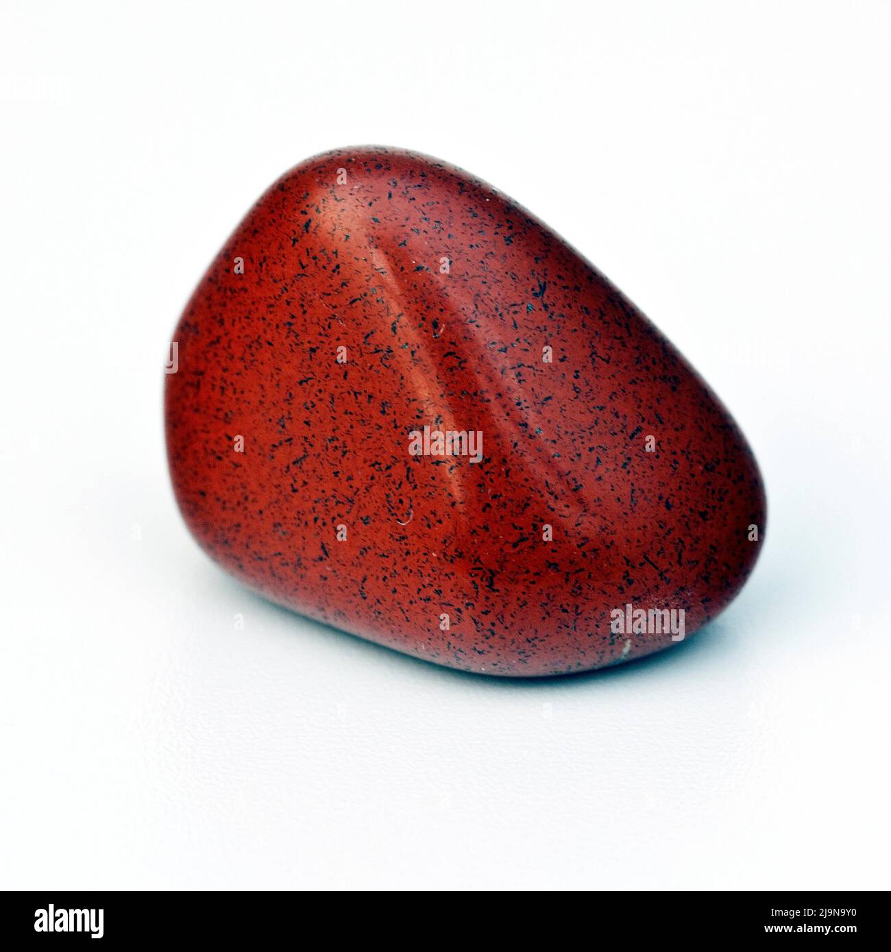Macro primo piano foto a colori di un lucido 'Jasper Rosso' una pietra di guarigione cristallo semi-preziosa Foto Stock