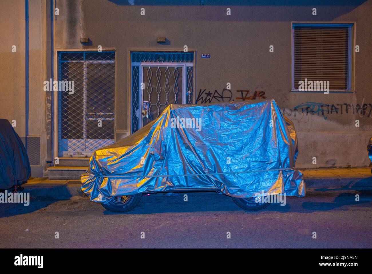Un'auto sotto copertura, fotografata di notte ad Atene Foto Stock