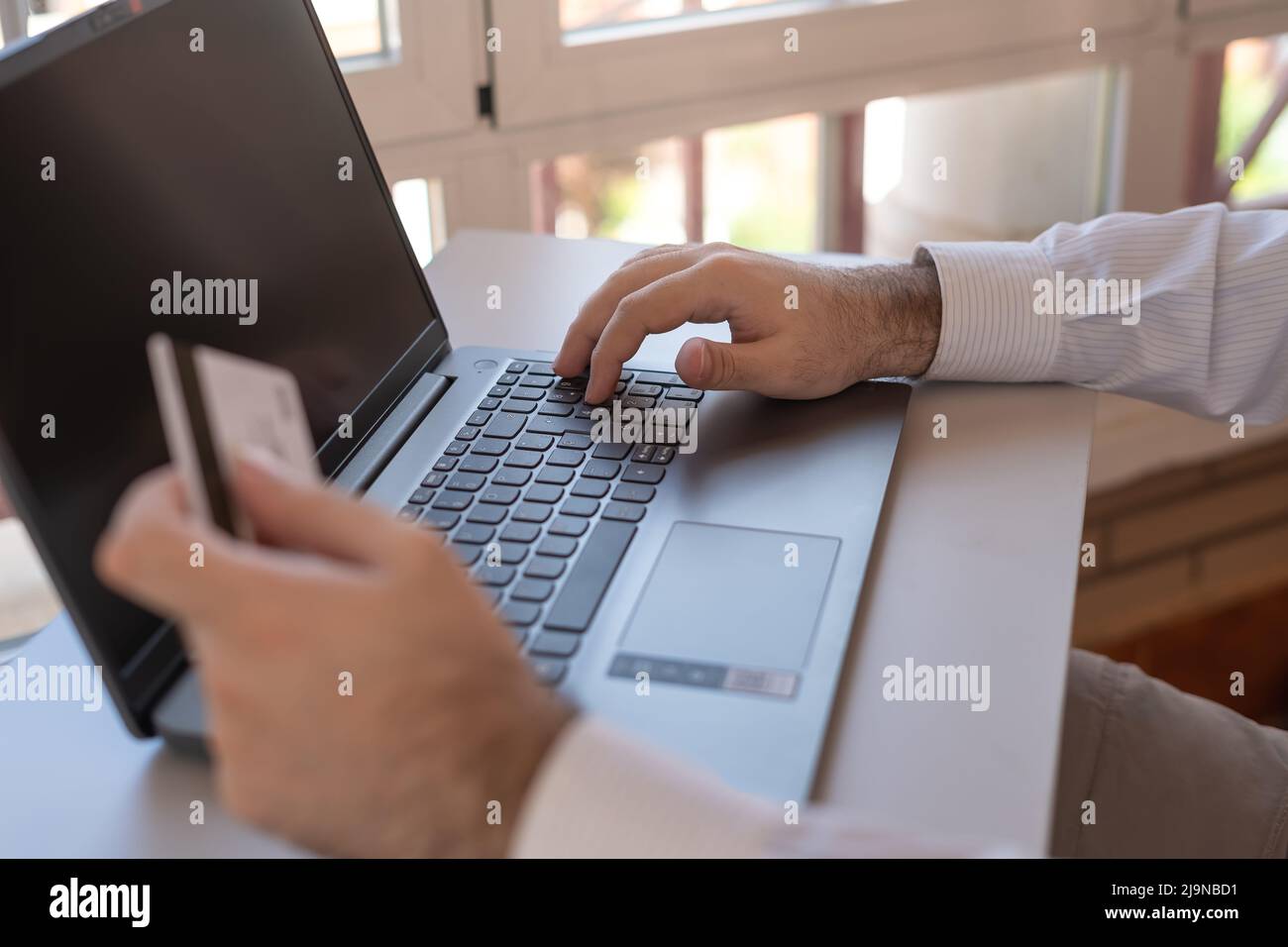 Uomo che paga con la sua carta di credito online con il portatile. Foto Stock