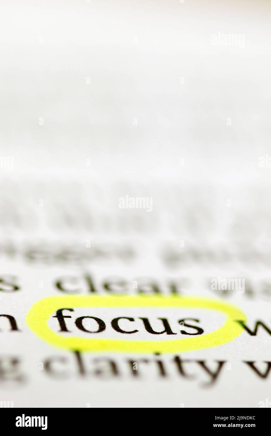 Primo piano della parola scritta focus cerchiata in un evidenziatore giallo fluorescente e stampata in inchiostro nero su carta a getto d'inchiostro bianca Foto Stock