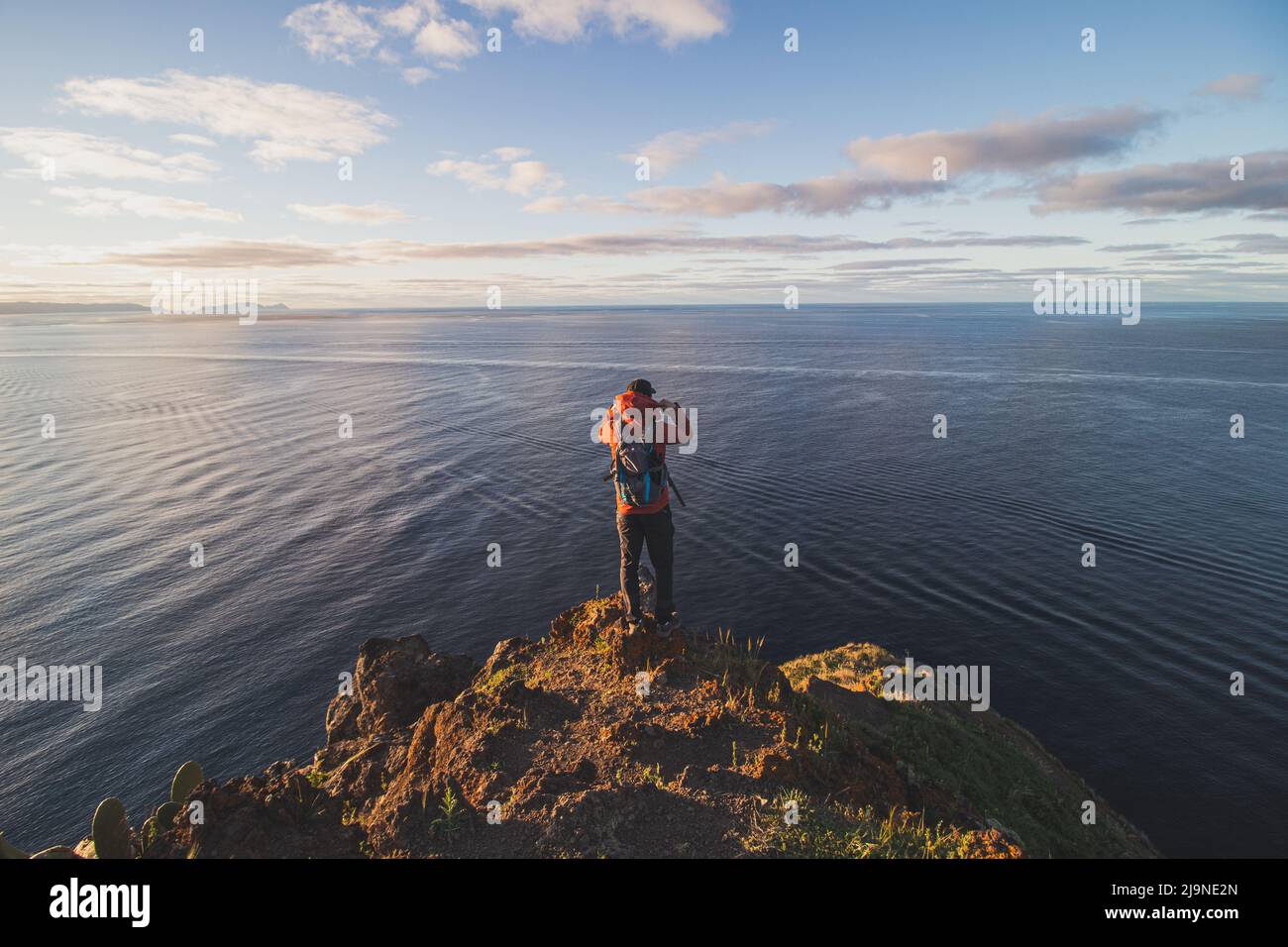 Appassionato zaino in spalla a 24 anni si trova sul bordo di una scogliera in un luogo chiamato Cristo Rei, Camara de Lomos, Madeira, appartenente al Portogallo. Dom Foto Stock