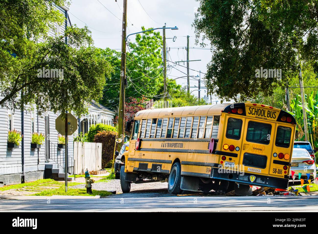 NEW ORLEANS, LA, Stati Uniti d'America - 9 MAGGIO 2022: Il bus scolastico è immobilizzato da pothole e strada di blocco nel quartiere Uptown di New Orleans Foto Stock