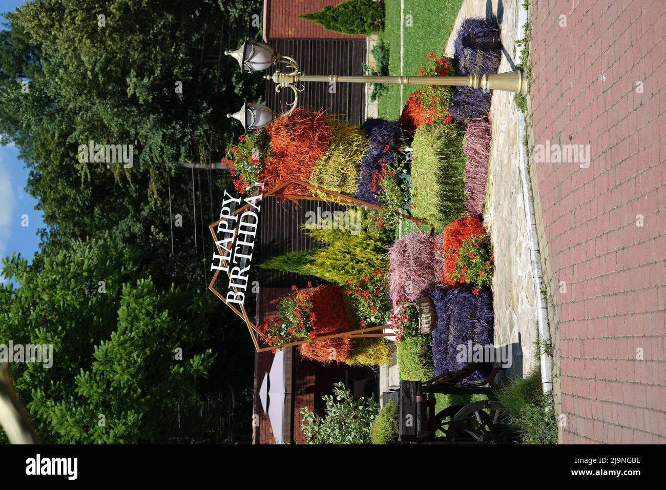 Felice area foto compleanno composta da balle di fieno naturale dipinte in diversi colori Foto Stock