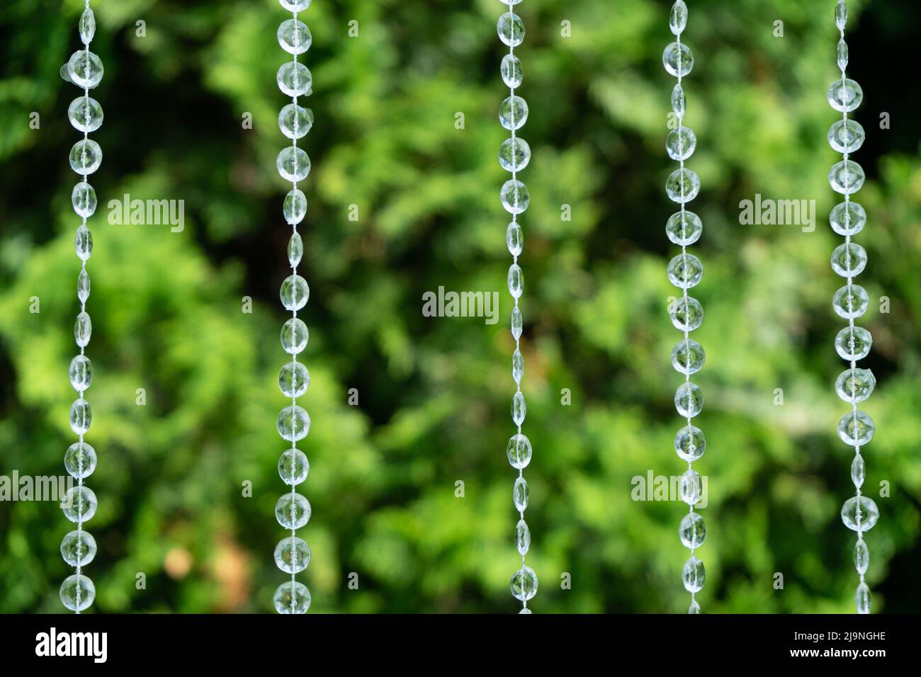 Decorazione con perline trasparenti su sfondo di verde sfocato Foto Stock