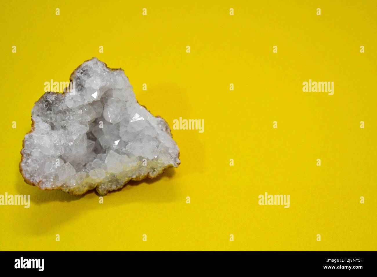 Splendido cristallo di quarzo chiaro geode su sfondo giallo Foto Stock