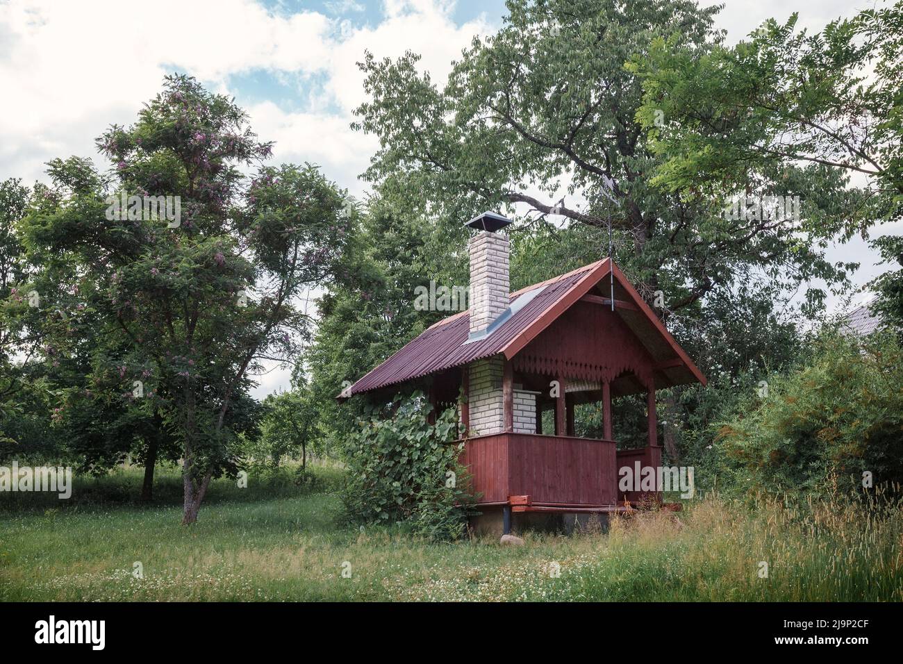 Gazebo per barbecue, padiglione e forno per barbecue nel giardino d'autunno. Luogo di relax per le famiglie nel cortile della casa. Frutteto, albero di mele. Foto Stock