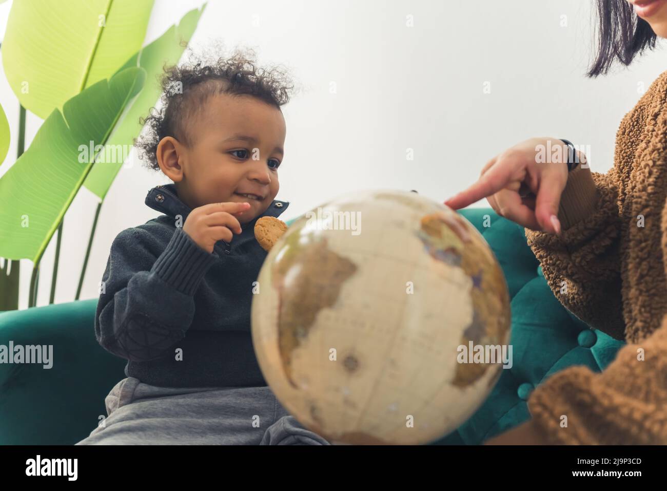 Afroamericana toddler dai capelli ricci e sua mamma che gioca con un globo . Foto di alta qualità Foto Stock