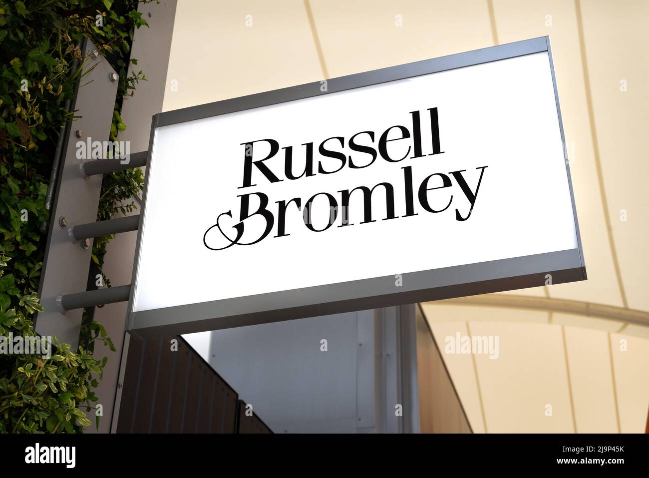 Primo piano dell'insegna del negozio di moda Russell e Bromley presso l'Ashford Outlet Center, Kent, Inghilterra, Regno Unito Foto Stock