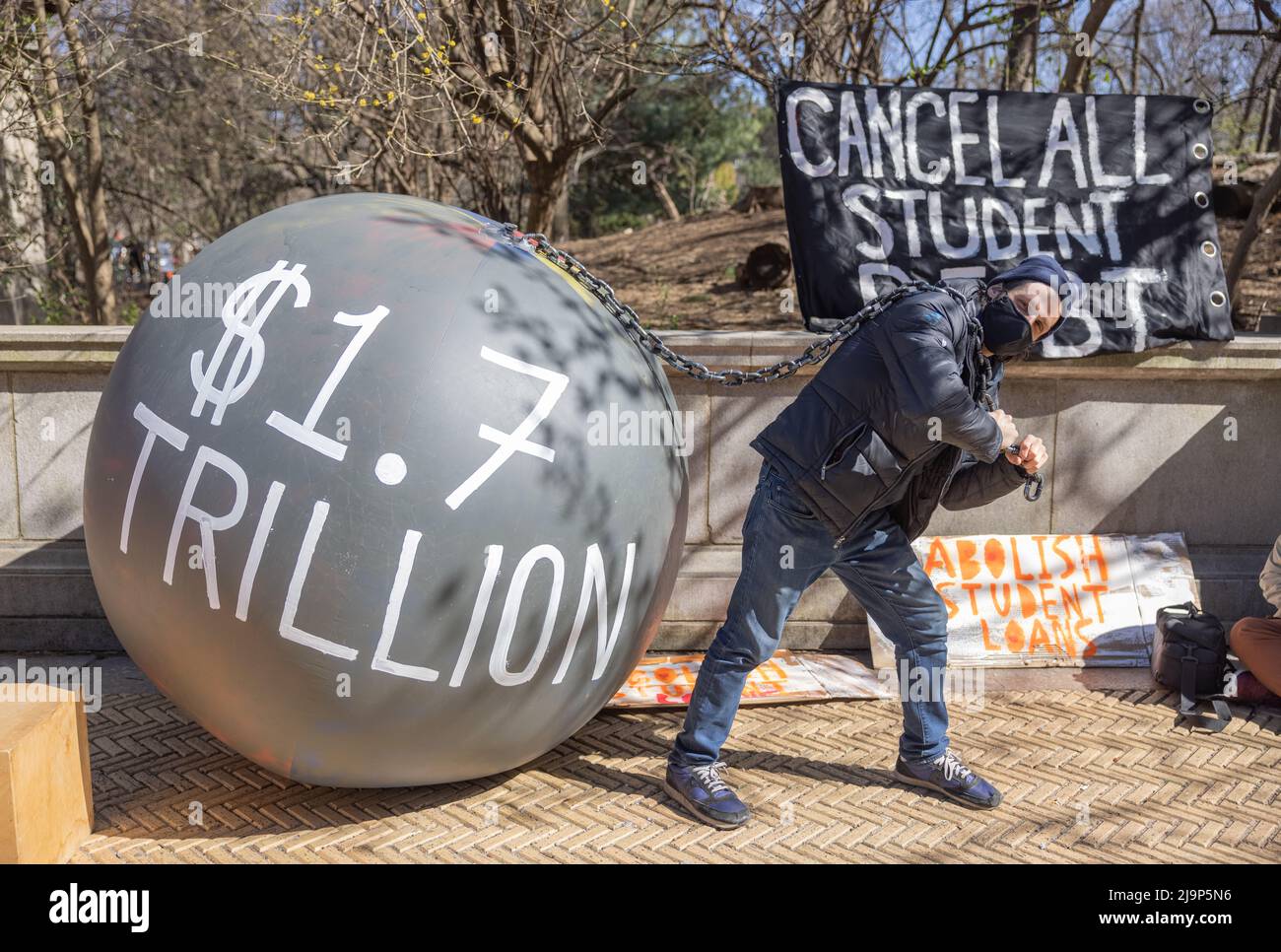 BROOKLYN, N.Y. – 3 aprile 2021: Un dimostratore protesta vicino al Grand Army Plaza durante un rally per cancellare i debiti di prestito degli studenti. Foto Stock