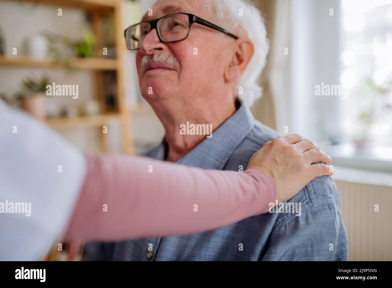 Operatore sanitario o operatore sanitario che visita l'uomo anziano in casa. Foto Stock