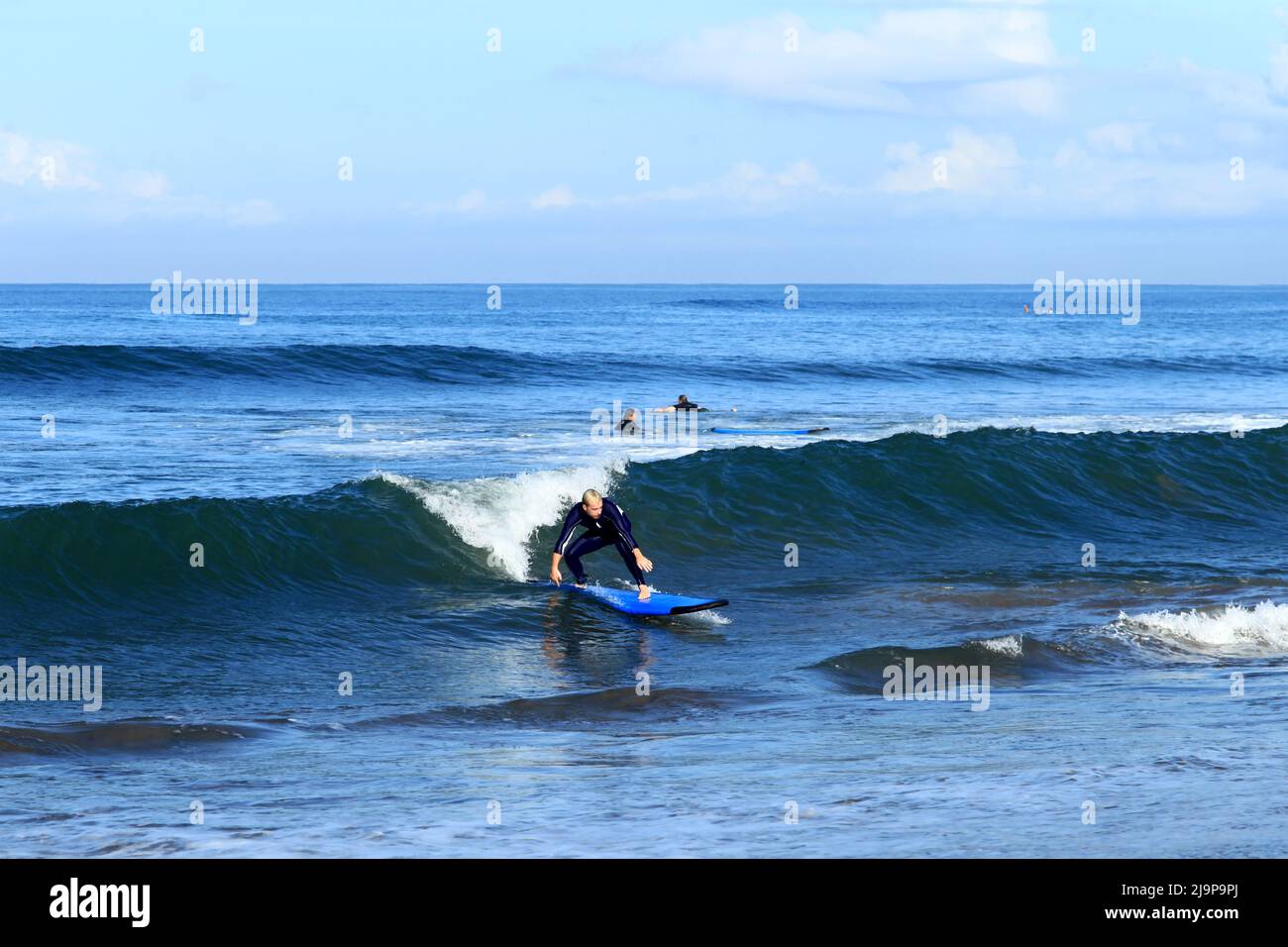 Un giovane surfista che cavalca un'onda a Batu Bolong Beach a Canggu, Bali, Indonesia Foto Stock