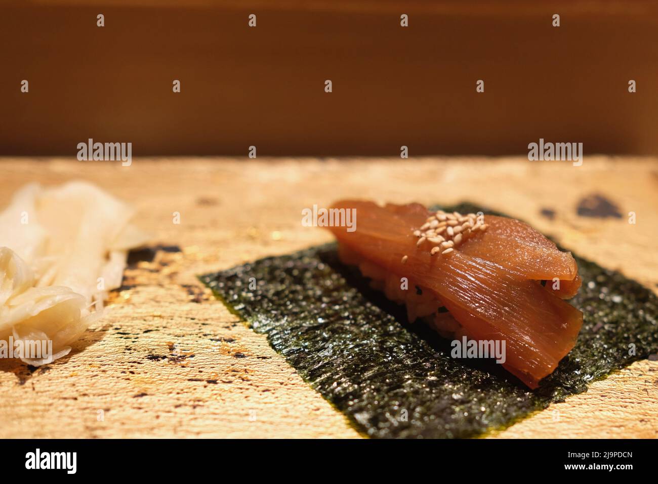 Un pezzo di sushi di nigiri con ravanello e zenzero sottaceto come parte di un pranzo omakase a Manten in Ginza - Tokyo, Giappone. Foto Stock