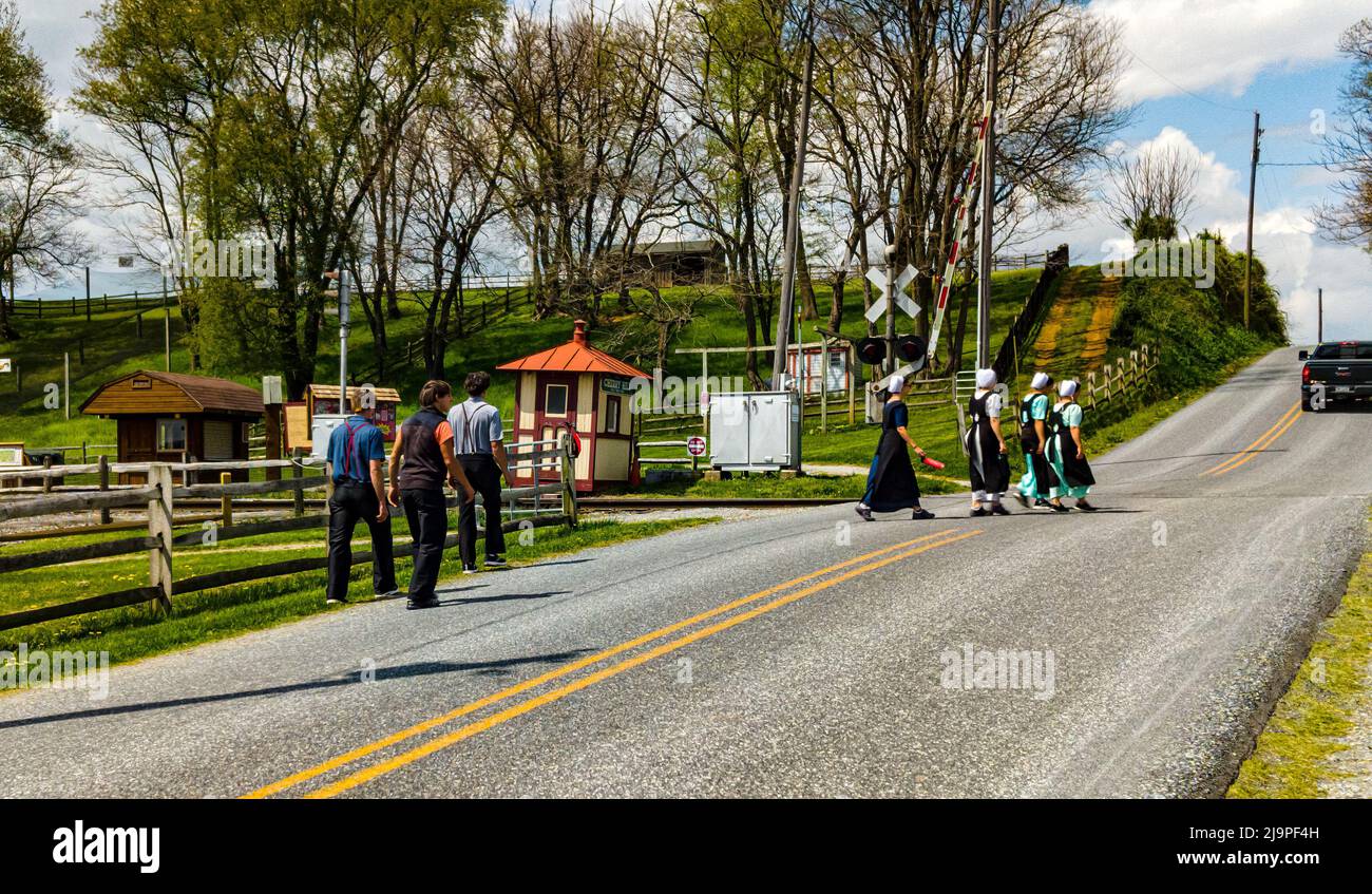 Ronks, Pennsylvania, Aprile 18,2021 - Teenage Amish ragazzi e ragazze che camminano lungo una strada rurale Foto Stock