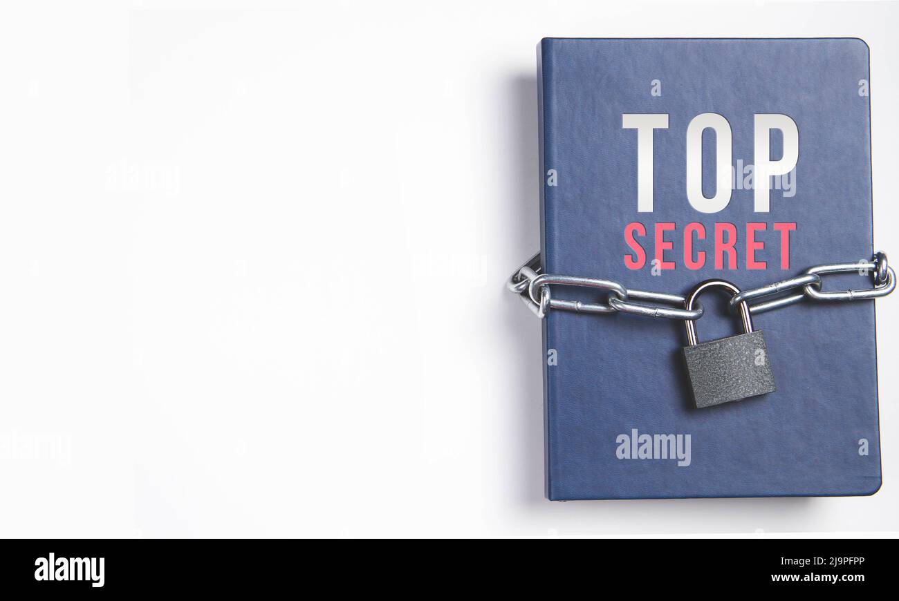 Il libro è bloccato sotto il lucchetto e si digita su uno sfondo bianco. Archivio segreto. Catena sul primo piano del libro. Il libro dei segreti è sotto la chiave e la serratura. Foto Stock