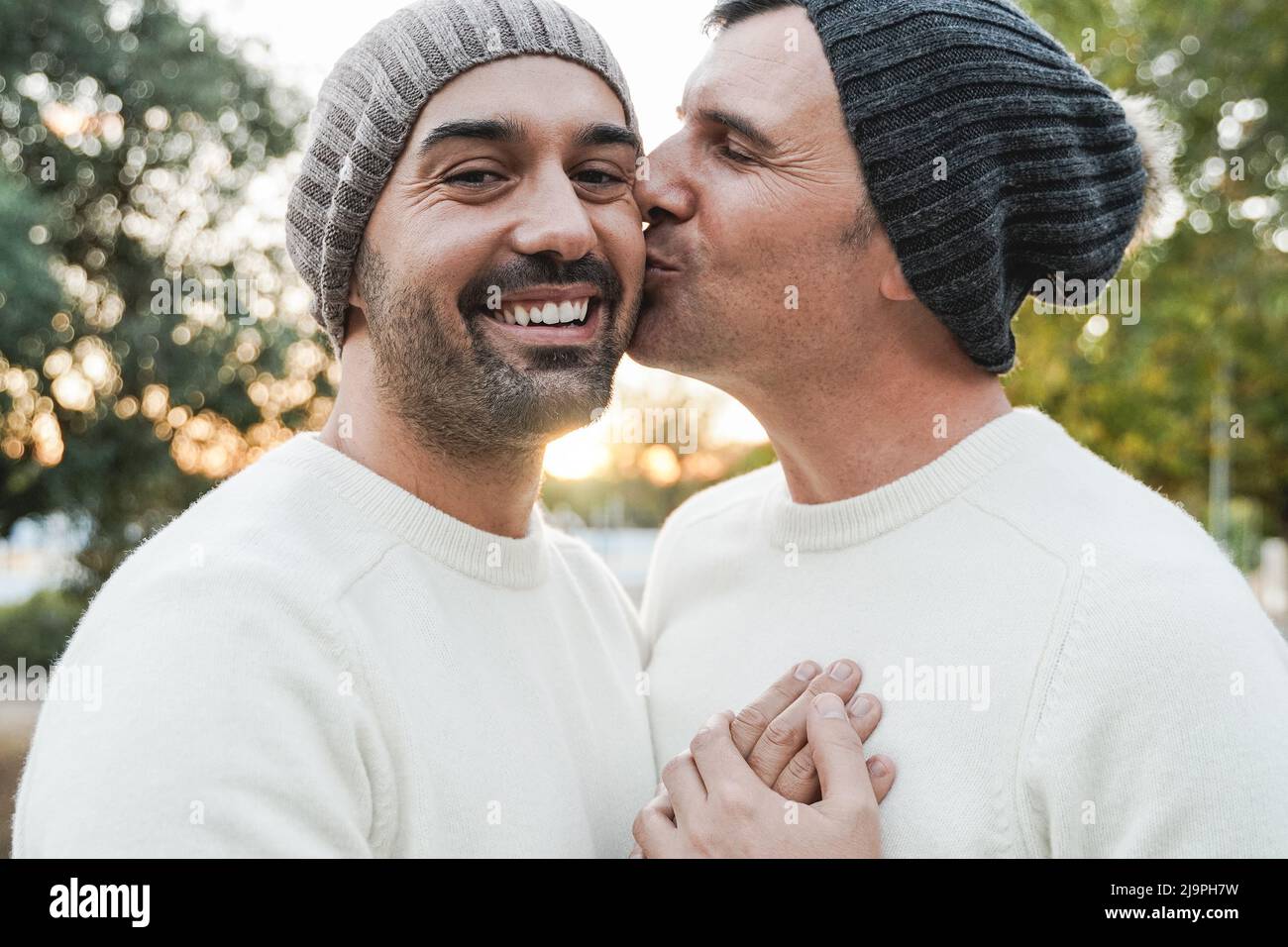 Coppia di uomini gay maturi che hanno momento tenero all'aperto - Focus sulla faccia sinistra dell'uomo Foto Stock