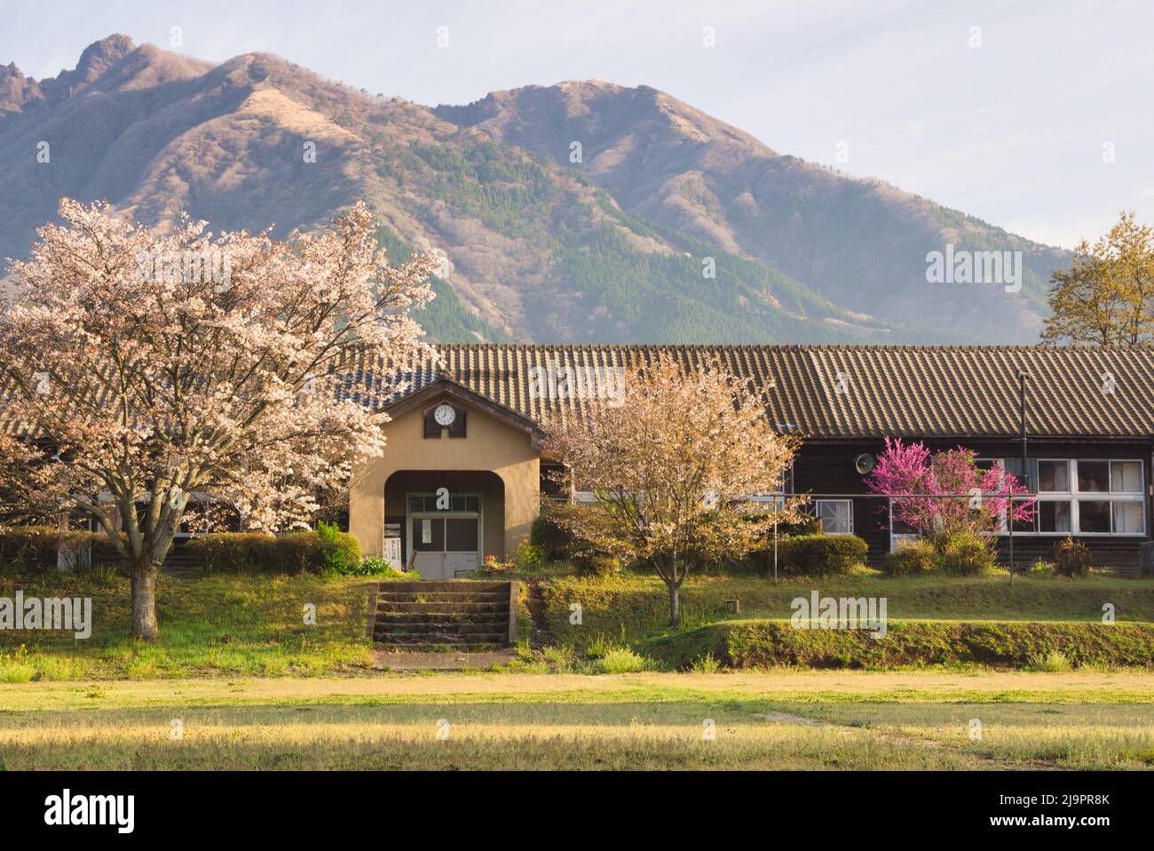 Scuola di legno e Mt. Nekodake ad Aso, Prefettura di Kumamoto, Giappone Foto Stock