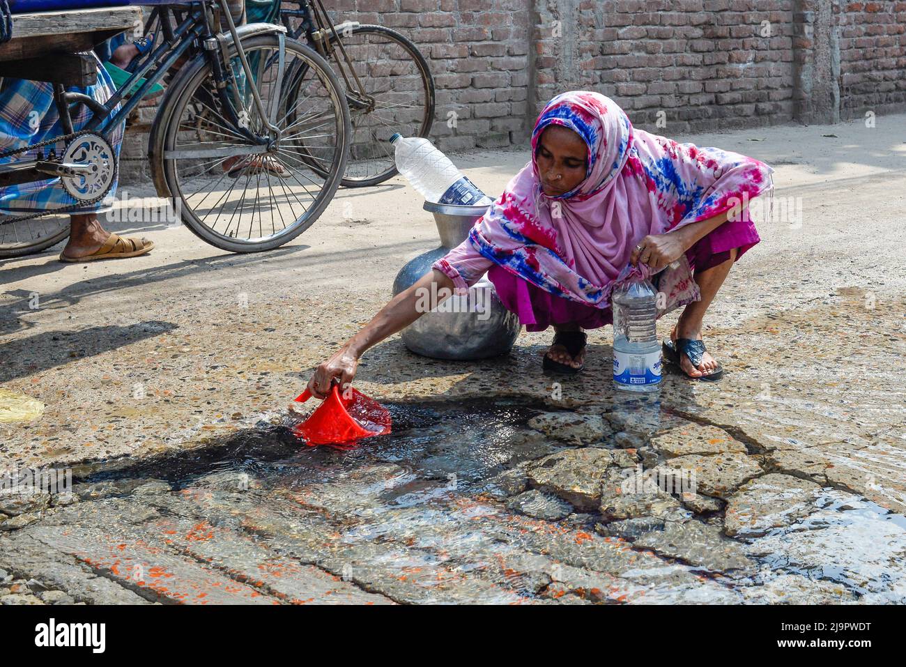 Dhaka, Bangladesh. 04th maggio 2020. Una donna raccoglie l'acqua potabile da un tubo dell'acqua rotto su una strada danneggiata in Dhaka. (Foto di Piyas Biswas/SOPA Images/Sipa USA) Credit: Sipa USA/Alamy Live News Foto Stock