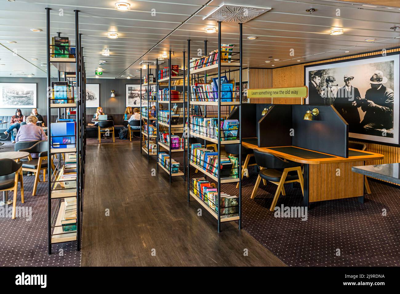 Impara qualcosa di nuovo nel vecchio modo. La biblioteca a bordo del Norröna offre angoli tranquilli per studiare. Foto Stock