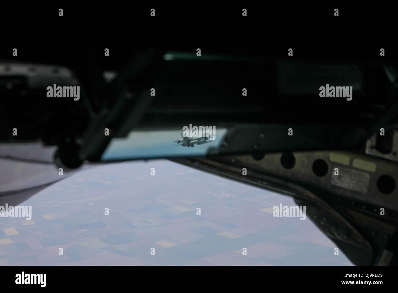 Lo specchio retrovisore di una Guardia Nazionale aerea Alabama 117th Air Refeling Wing KC-135 rivela una forza aerea rumena F-16 che si avvicina per un rindezvous medio-aria di rifornimento sopra Bucarest, Romania, 17 maggio 2022. Questo sortie ha coinvolto il rifornimento di aria media di quattro combattenti rumeni F-16 in generale (U.S.A. Foto dell'esercito dello staff Sgt. Samuel Hartley). Foto Stock