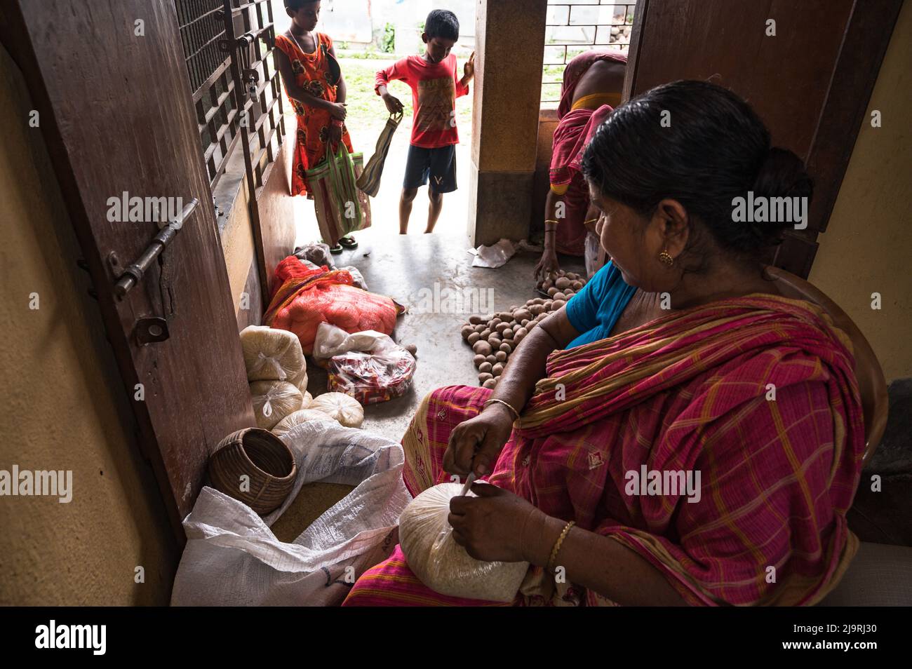 24 maggio 2022, Tehatta, Bengala Occidentale, India: Il governo del Bengala Occidentale ha diretto le scuole di governo di stato a distribuire le forniture di pasto di metà giorno ai genitori degli allievi durante le vacanze di estate in modo che i bambini bisognosi non siano privati del programma. L'avviso ha detto che ogni studente avrebbe ottenuto 2 kg di riso, 2 kg di patate, 250 grammi di zucchero, 250 grammi di legumi, e una saponetta. Così gli studenti sono venuti in una scuola elementare per ottenere i loro prodotti alimentari durante le vacanze estive e alcuni di loro stanno anche aiutando a dare gli articoli alimentari a Nabin Nagar, West Bengala. (Credit Image: © Soumrabyata Roy/Pacific Foto Stock