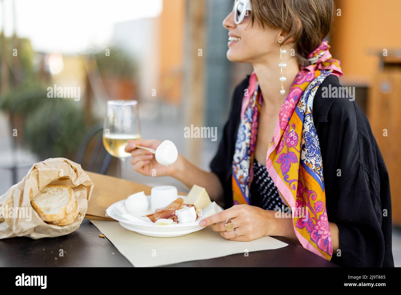 Donna che degusta formaggio e vino presso un'azienda agricola locale in Italia Foto Stock