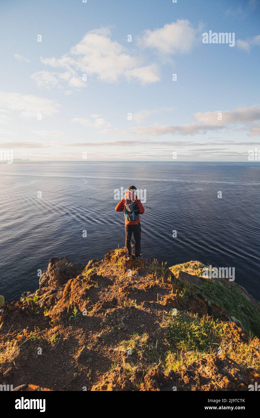 Appassionato zaino in spalla a 24 anni si trova sul bordo di una scogliera in un luogo chiamato Cristo Rei, Camara de Lomos, Madeira, appartenente al Portogallo. Dom Foto Stock