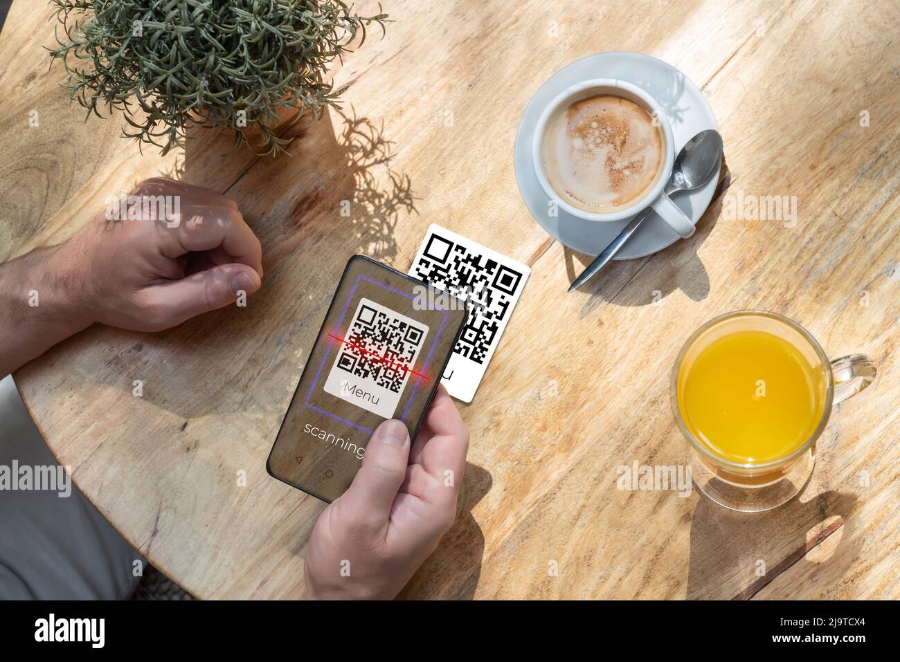 Un cliente che esegue la scansione di un codice qr con il proprio telefono cellulare in un bar o in un ristorante per leggere il menu. Il settore alberghiero e le nuove tecnologie Foto Stock